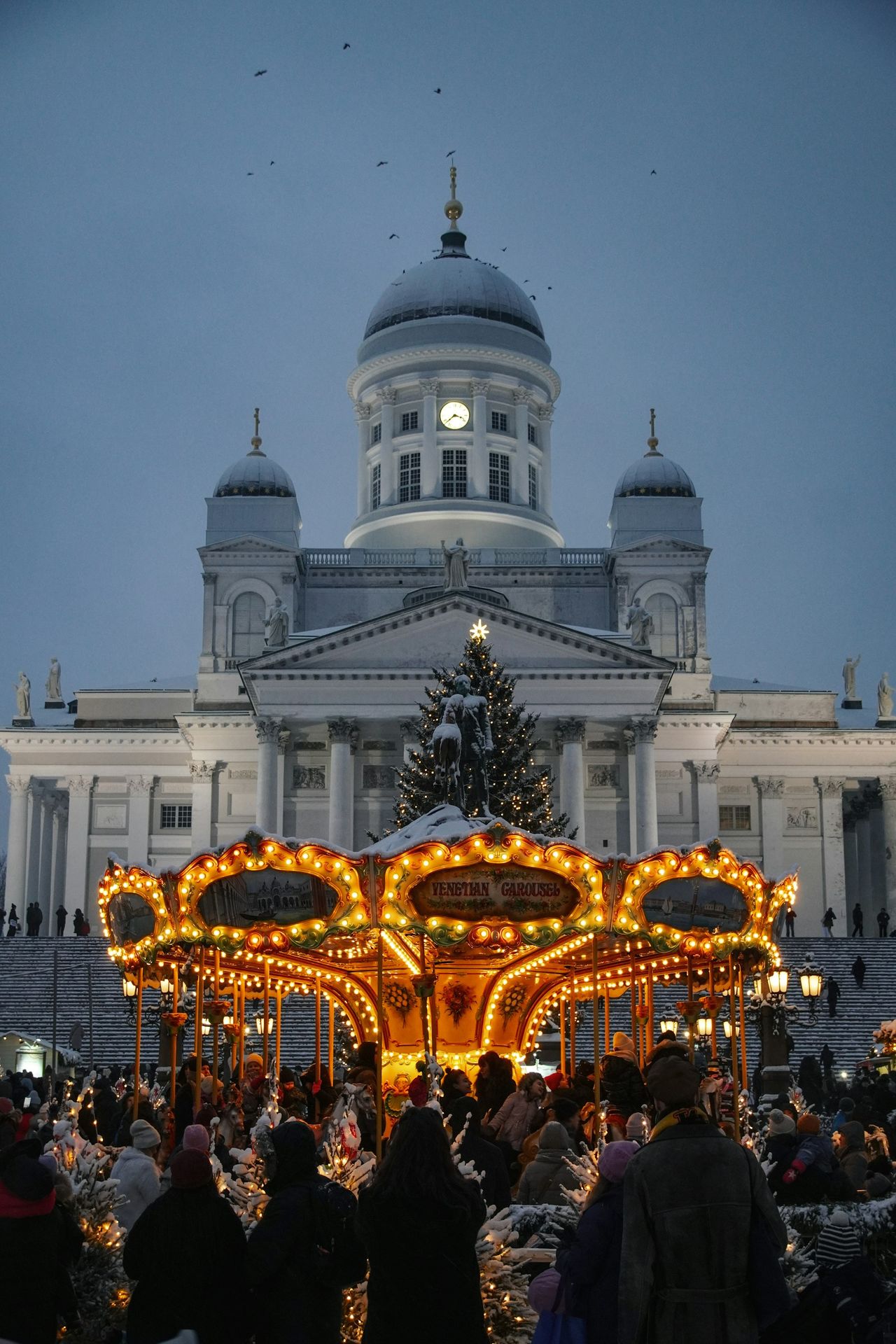 A merry go round in front of a large building